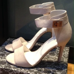  - Beiga sandaler med klack från nelly.com. Metall spännen i roséguld. Helt nya i kartong, extra klack medföljer. 