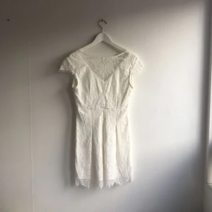  - Vit spetsklänning som är öppen i ryggen. Aldrig använd. Perfekt studentklänning