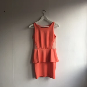  - Korallfärgad peplumklänning. Använd ett fåtal gånger.