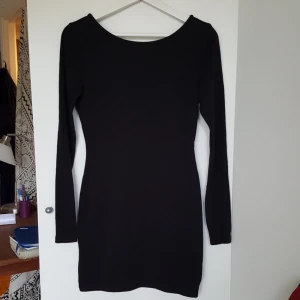  - Svart tight klänning med snygg korsning i ryggen! Sparsamt använd och därför Mycket bra skick. Frakt tillkommer