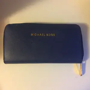 Mörkblå plånbok från Michael Kors. Den är i nyskick