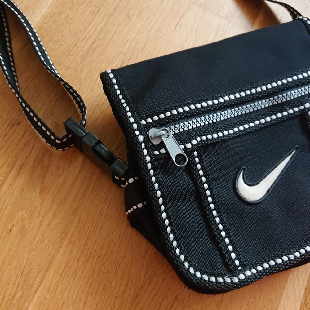 Mindre svart väska från Nike med justerbar axelrem, i fint skick! . Väskor.