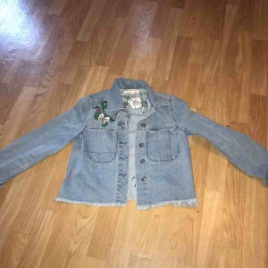  - Jeansjacka med blomdetaljer från H&M, använt endast 2 gånger och är i nyskick. Storlek: S (36), Pris: 100 kr frakt tillkommer