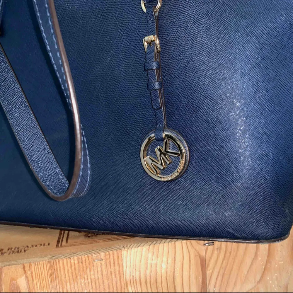 Denna Michael Kors handväska är i modellen Jet Set medium tote och färgen marinblå. Väskan är i princip helt utan slitage och generellt i ett mycket gott skick. Inköpspriset var 2700 kr. Väskan är självklart äkta och köpt från NK i Stockholm. . Väskor.