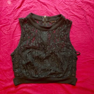  - Superfin crop top köpt i New York i svart spets med dragkedja bak och snörning i sidorna. Jättebra skick! 