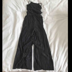  - halterneck överdel och benen på byxdressen är lite kortare (culottes). Ett resårband i midjan. Ej använd. Tunn och skön.