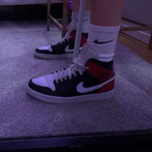 Air Jordan 1 - Säljer nu mina älskade mina air Jordan 1 mid black, white and Nobel red. Fina i skick och sparsamt använda
