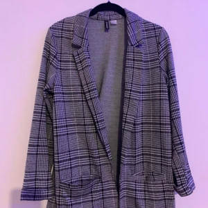 En lång grå kavaj från H&m, storlek S. - En lång kavaj i trikå. Kavajen har trubbigt slag och fickor fram. 