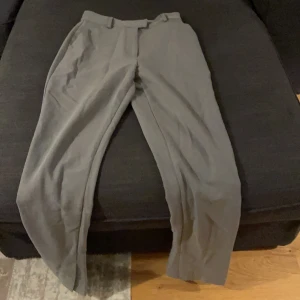 Grå kostymbyxor - Grå vida kostymbyxor med en liten slit vid benslutet. Kan ek ta kort på då dom ej passar. Frakt ingår