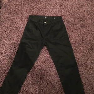 Carhartt canvas byxor - Ett par svarta Carhartt byxor i canvas. Sköna skatebyxor som är sparsamt använda, Storlek 28/Small. Modellen heter Abbott pants.