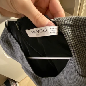 Figursydd klänning i grå  - Väldigt modern och snygg klänning i grå, den är figursydd och otroligt fin. Använd enstaka gånger, inget slitage, den är som ny. 