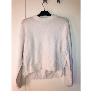 Stickad tröja - Vit stickad tröja med röd text på ryggen. Storlek S, passar m också