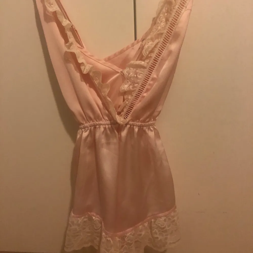 Säljer denna playsuit från Nelly, använd en gång. Babyrosa silkes material med spets på kanterna. Köparen står för frakten. Märke missguided. Korsad i ryggen. Övrigt.