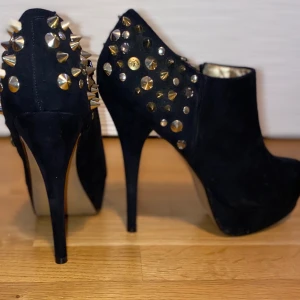 Bianco högklack strl 39 - Svart klack med mockaimitation & guldnitar i storlek 39. Använda endast en gång, i mycket bra skick. Nypris: 700kr (se bild 3).                                                                                       Klackhöjd: 11cm. 