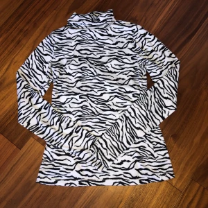 Stl XS - Zebra mönstrad tight tröja med polokrage.🦓