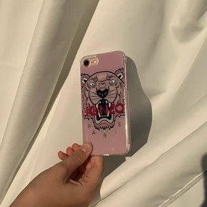 Kenzo mobilskal  - Jag säljer detta  jätte fina rosa kenzo skal som passar för iPhone 7/8. Skalet är använt men det är i bra skick. Som man kan se på den tredje bilden så har ett av hörnen lite repor men det syns knappt. Ordinarie priset ligger på 750.