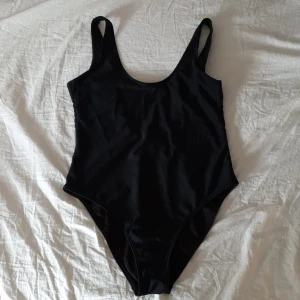 Svart baddräkt - Svart baddräkt från boohoo med djup rygg. Oanvänd. Strl 38-40 men passar snarare 36-38. Säljes pga för liten. Frakt tillkommer 