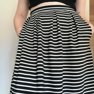 Randig Vila kjol - Vintage inspirerad super söt kjol från Vila med svart vita ränder längs hela plagget. Toppen skick väldigt sparsamt använd. Ger retro vibes i passformen och mönstret! Storlek XS men passar även S utan problem. 80kr utan frakt Möts i sthlm eller fraktar