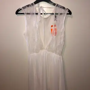 Superfin vit klänning som visar ryggen med spetstyg. Strl M/L. Oanvänd klänning nypris 400kr, säljer för 190kr. Pris går att diskutera.