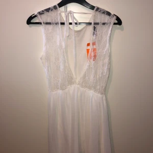 Vit klänning med spetsdetaljer - Superfin vit klänning som visar ryggen med spetstyg. Strl M/L. Oanvänd klänning nypris 400kr, säljer för 190kr. Pris går att diskutera.