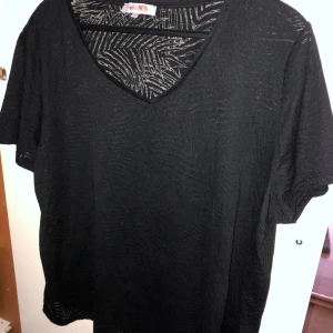 Svart kortärmad tröja  - Svart mönstrad kortärmad tröja. Strl XL men passar L