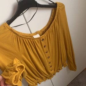 Off shoulder tröja - Säljer min gula off shulder tröja för den inte kommer till användning. Den är super bekväm och köpt från H&M för 250kr men säljs för 35kr. Inget är söndrigt och är i nyskick. Frakten betalas av dig. Priset på frakt återkommer❤️