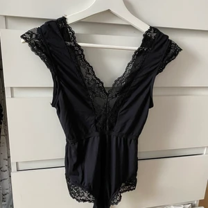 Svart body i satin  - Svart body i satin med spets. I storlek X-SMALL. Använd endast en gång så som ny 🖤 köparen står för frakten 