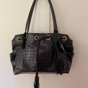 Ny väska från Vezzano (prislapp finns kvar) - Denna väska är oanvänd,som ni ser hänger prislapp kvar.Legat lite ihop vikt,men den rättar nog till sig när den börjar att användas..Mått cirkus:40cm bred och en höjd på 25cm..på ena sidan finns nån form av skavank..jag vill inte hålla på och pilla på det,så jag överlåter det till köparen,pälsdjur finns i hemmet.