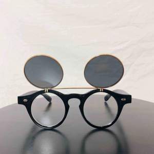 Solglasögon med uppfällbart glas från LA. Yoko Ono style. Bågarna är runda och små. Googla Johnny Depp sunglasses så får du en bra känsla för deras dimensioner. Frakt 59:-