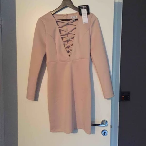  - Snygg klänning i strechigt material som ändå slimmar åt! Helt ny. Köpt från Nelly.com