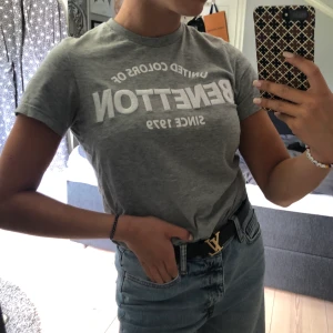 T-shirt med text - Grå T-shirt från benneton med texten ”BENNETON”, FRAKT INGÅR I PRISET, kontakta för fler bilder eller frågor, buda gärna
