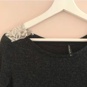 Tröja  - Svartgrå tröja med vit spets på axlarna