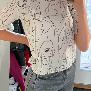 Blommig vit svart blus ifrån NAKD 32 - Blommig svart och vit blus ifrån NAKD i storlek 32 Använd? : Max 3 gånger Anledning till försäljning : kommer inte till användning Hur är storleken? : Jag som har minsta storleken i nästan alla kläder passar den bra på. Den är true to size.  Jag : 162cm Originalpris : 299kr Frakt betalas av köparen och ingår inte i nuvarande priset