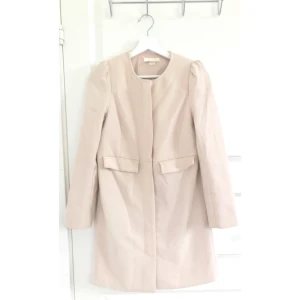  - Säljer denna ljusrosa korta kappa ifrån H&M. Guld dragkedja och fickor på sidorna. Knappt använd. I bra skick. (Kanske behöver strykas lite)