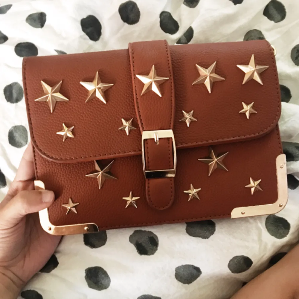 En sjukt snygg rödbrun väska med stjärnor på. Endast använd en gång så den är i perfekt skick.. Väskor.