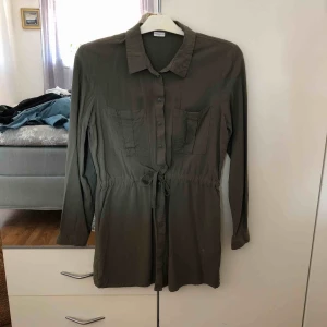  - Grön tunika men knytning i midjan. Endast testad. Frakt tillkommer