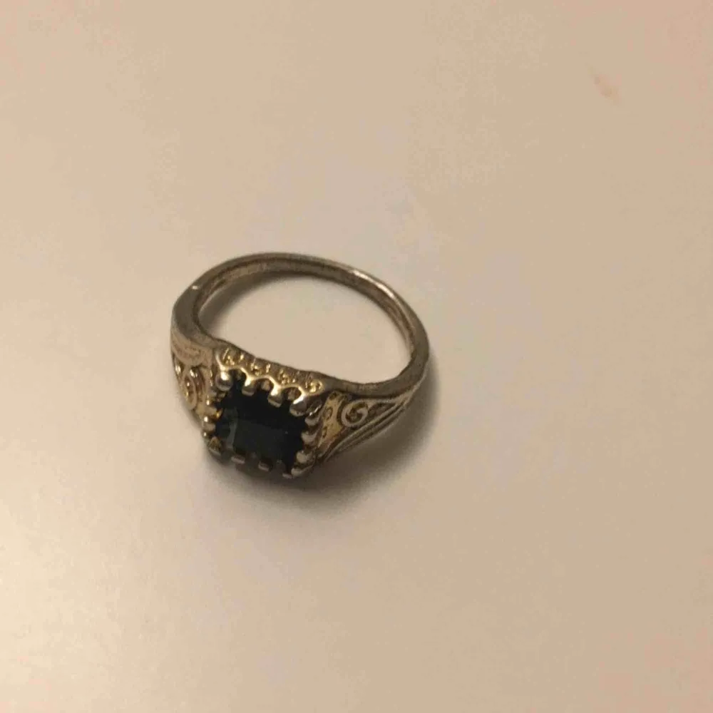Guldfärgad ring med liten svart sten. Möts i Örebro eller skickar, köparen står för frakt. Accessoarer.