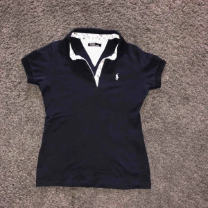  - Ralph Lauren piké. Märkt M men liten i storleken.  Mörkblå 