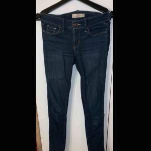 Mörkblåa jeans från Hollister i använt skick. Storlek: W 24 L 33 Köparen står för den eventuella fraktkostnaden.