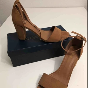  - Nya, aldrig använda klackar i mockaimitation, bred klack och knäppning runt ankeln. Sköna på foten. 