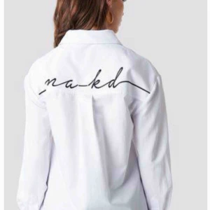  - Vit lite oversize skjorta från NA-KD men logo på ryggen. Använd 1 gång