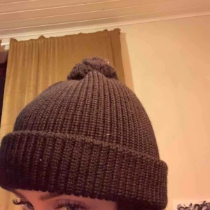  - Stickad svart mössa! Med en liten fluffboll på toppen.  100kr frakten ingår i priset <3