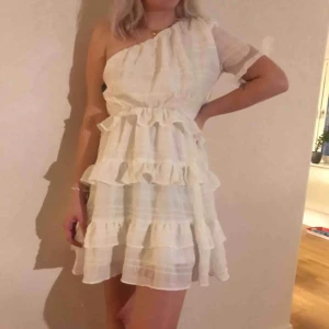  - Superfin vit klänning med volanger! Använd 1 gång som studentklänning.