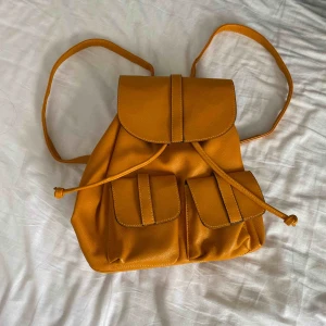  - Senapsgul ryggsäck från even&odd. Aldrig använd. Vid frakt står köparen för fraktkostnaden.