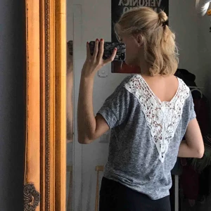  - Gråmelerad t-shirt med fin spets i ryggen från ett franskt märke vid namn Jennyfer!