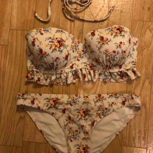  - Blommig bikini. Underdelen är i storlek 34, överdelen 40. Frakt tillkommer