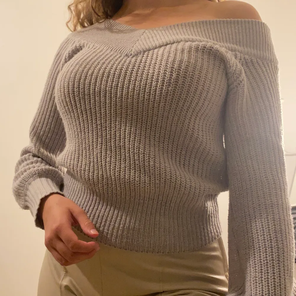 Grå stickad tröja från Gina Tricot med offshoulder. Långa ärmar och en tajtare mudd längst ned på tröjan. Storlek XS. Använd ett fåtal gånger så mycket bra skick! Frakt tillkommer . Stickat.