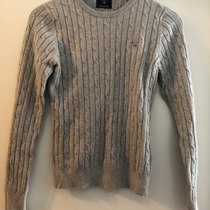 Grå kabelstickad gant - En superfin knappt använd grå kabelstickad gant-tröja. Storlek 170 (XS). Bra pris vid snabb affär! 