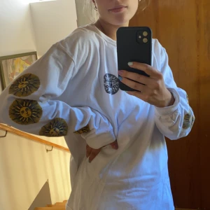 Långärmad tröja med soltryck - Ascool tröja med soltryck på ärmarna och baksida från UO i storlek M, sitter lite oversized om man har storlek S/XS men ser bra ut ändå. Endast använd ett fåtal gånger så är i perfekt skick!