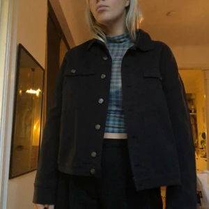 Svart Höstjacka - Lätt, midjekort jacka från Weekday. Jättefin med en hoodie under eller inomhusjacka med topp under. Kan även stängas och användas som en jackskjorta.